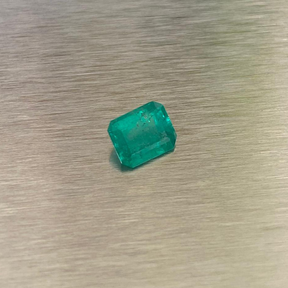 0.51 ct natural Muzo Colombian emerald, angled face-up view showing step-cut facets