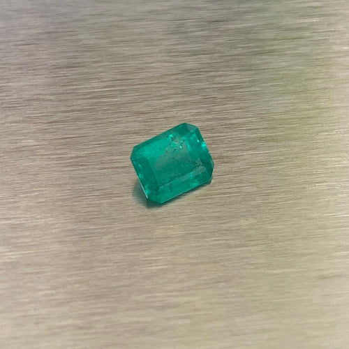 0.51 ct natural Muzo Colombian emerald, angled face-up view showing step-cut facets