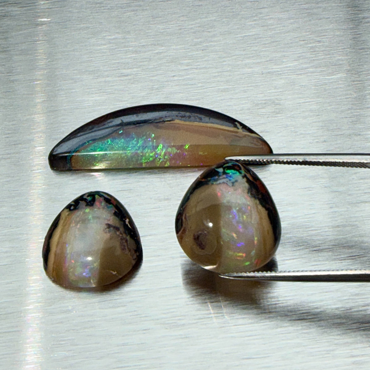 Australian boulder opal suite showing matched cabochon pair and crescent piece, alternate view, Otzera OTZ-2026-00328