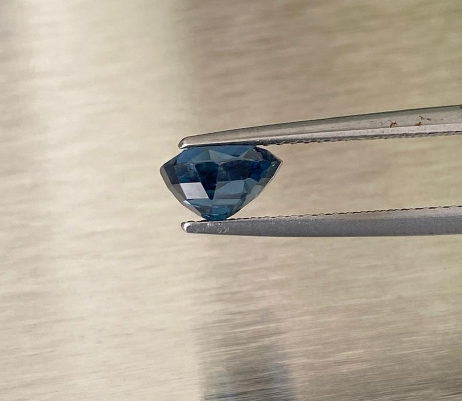 2.14 ct blue sapphire, profile view in gemological tweezers