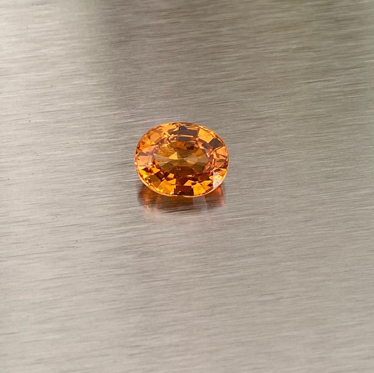 2.14 ct orange spessartite garnet, face-up view on metallic background