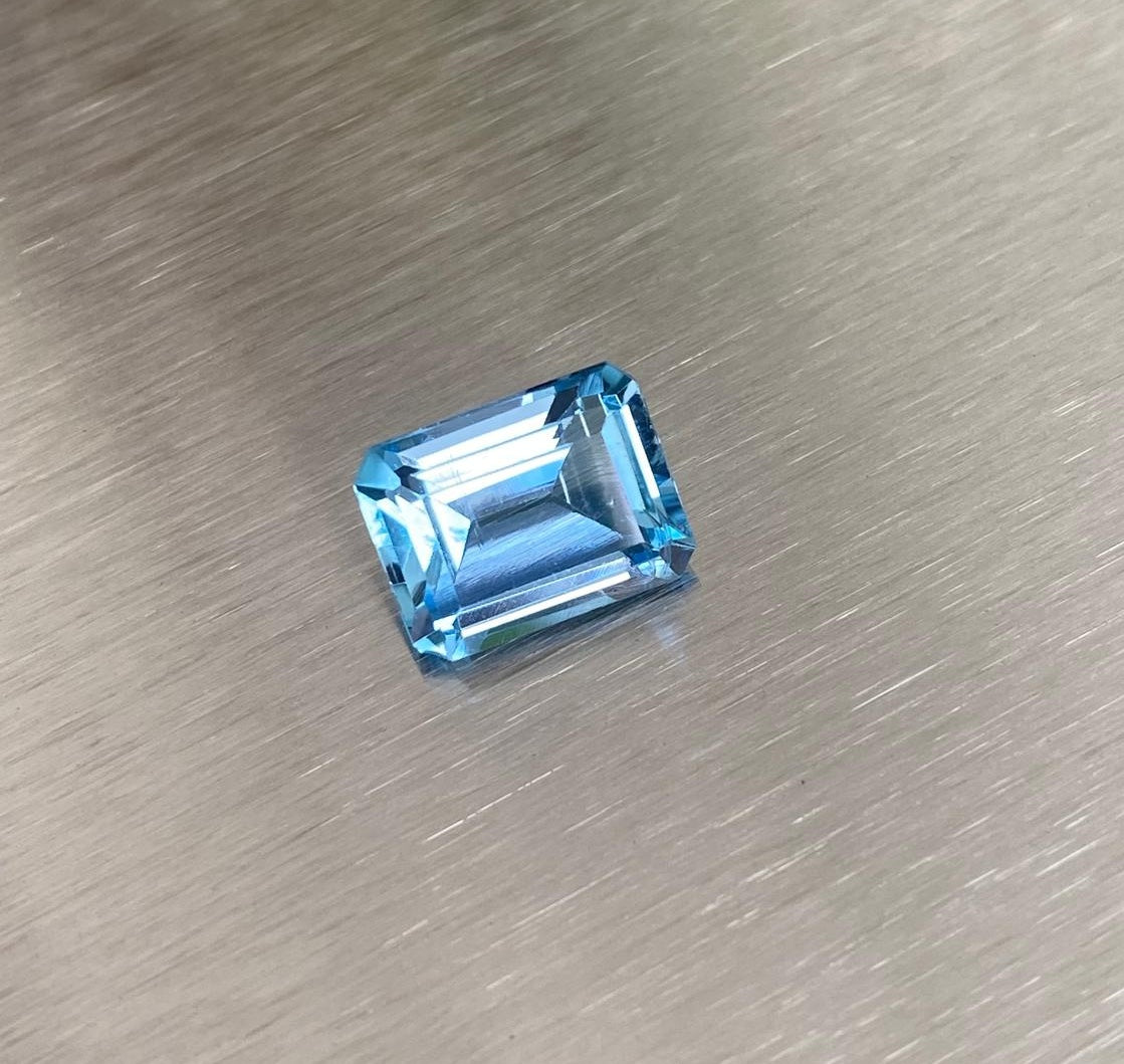 3.22 ct aquamarine, alternate face-up emerald-cut view on metallic background