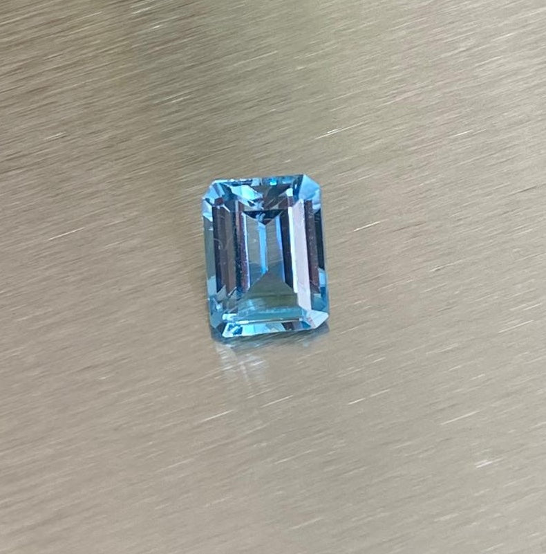 3.22 ct aquamarine, angled emerald-cut view on metallic background