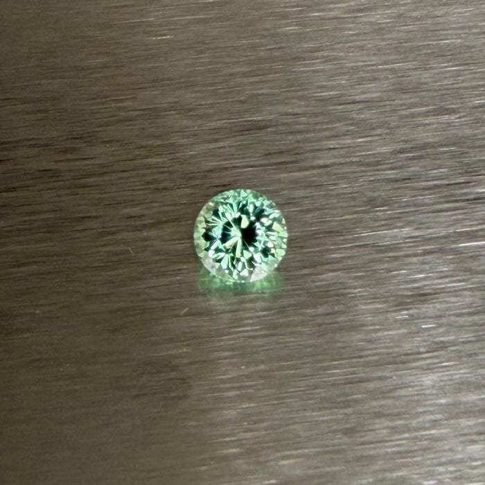 1.70 ct Merelani mint grossular garnet held face-up in tweezers, round modified brilliant cut, Otzera OTZ-2026-01636