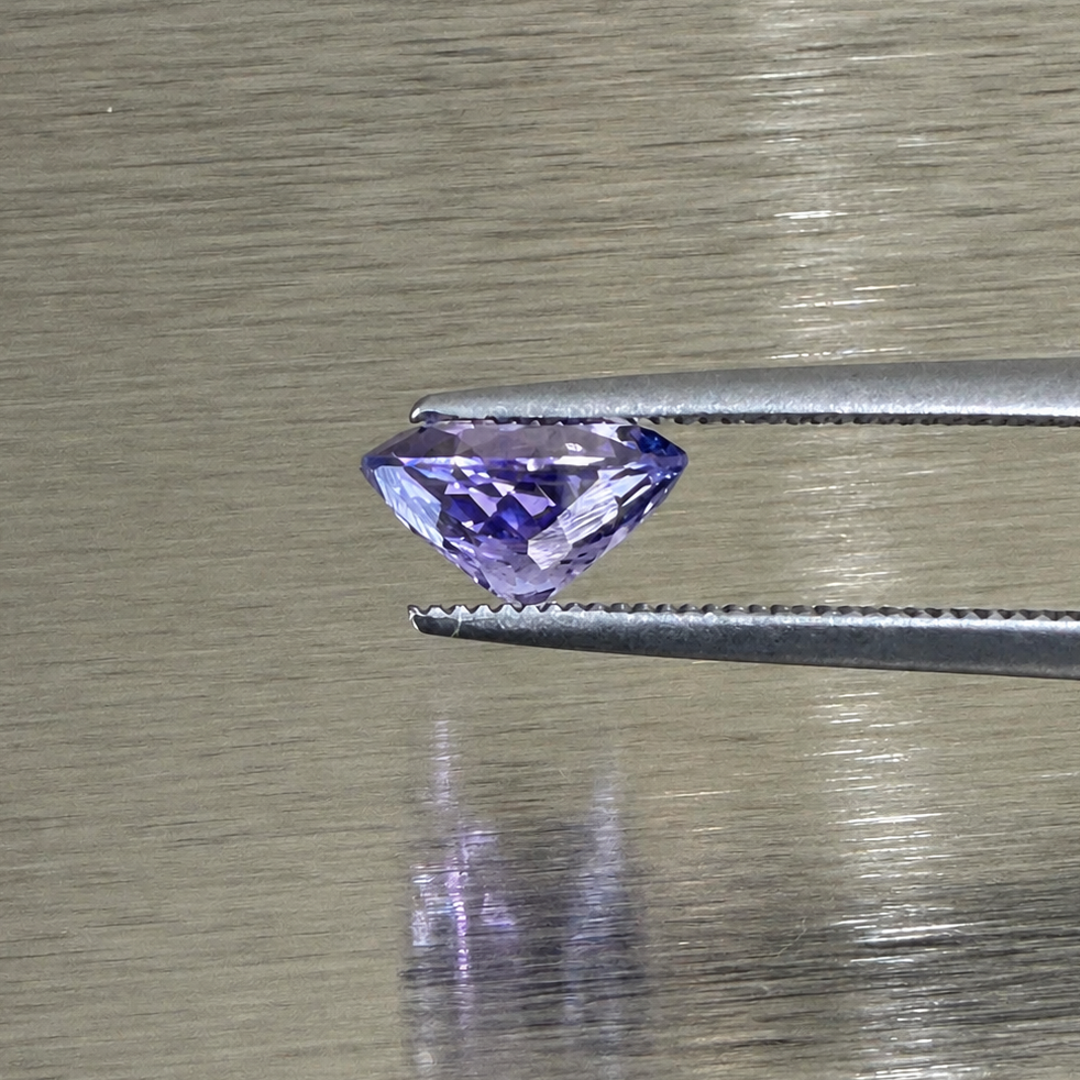 1.57 ct natural purple sapphire oval modified brilliant side profile in tweezers