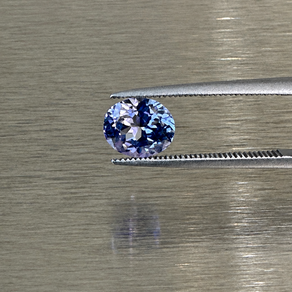 1.57 ct natural purple sapphire oval modified brilliant face-up in tweezers