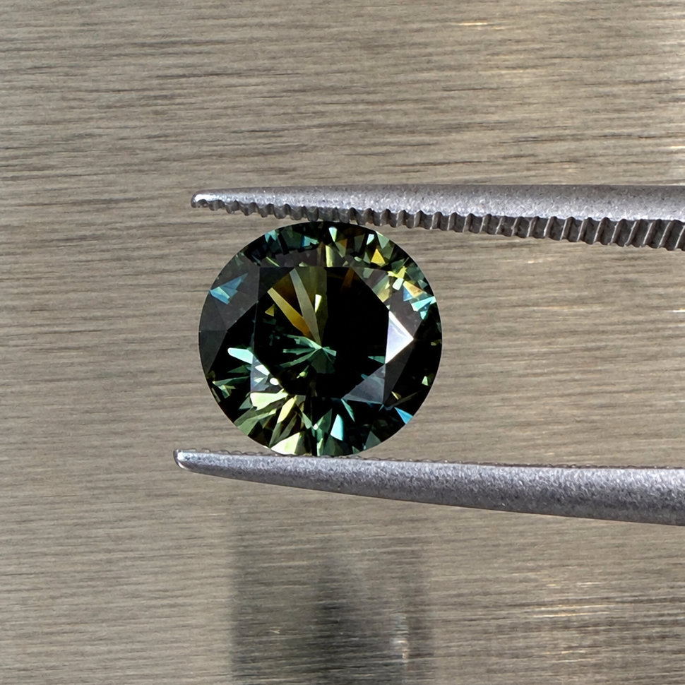 2.32 ct natural green sapphire round brilliant face-up view in tweezers