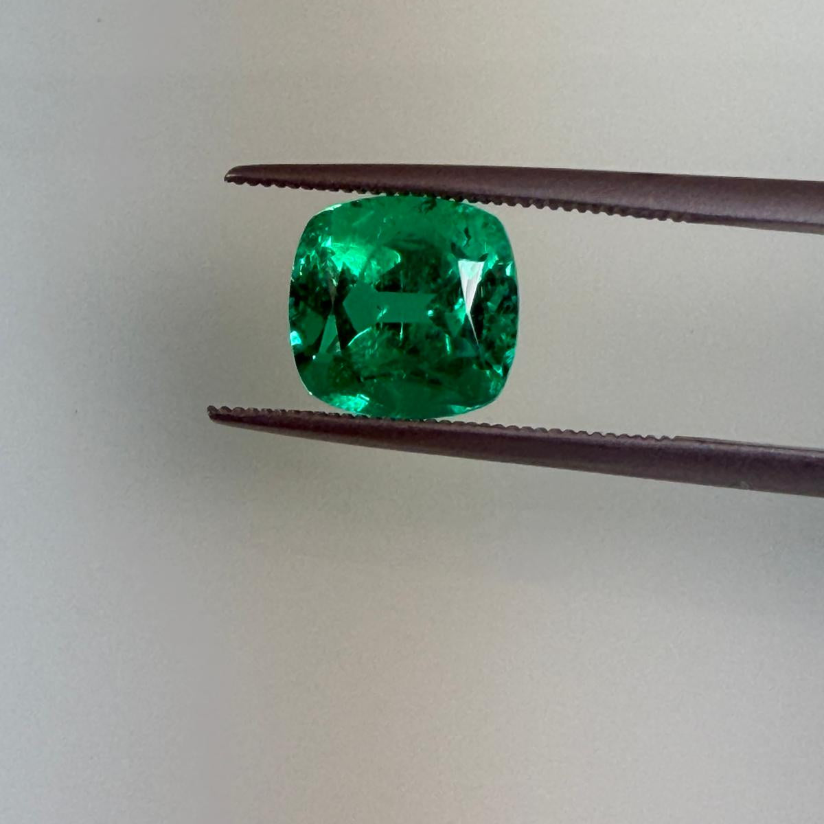 2.94 ct natural Colombian emerald held in tweezers, face-up view, Otzera OTZ-2026-01642