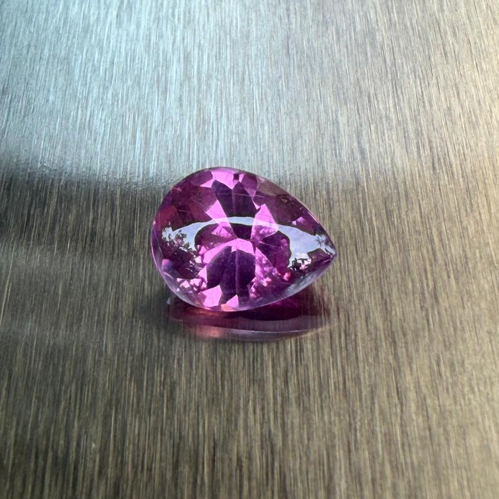 3.19 ct raspberry rhodolite garnet in a pear-shaped buff-top mixed cut, face-up view, Otzera OTZ-2026-01649