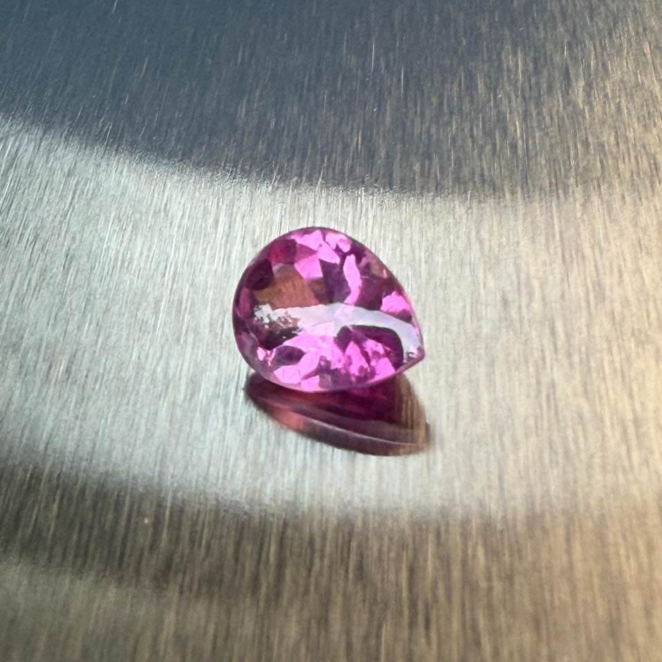 3.19 ct raspberry rhodolite garnet in a pear-shaped buff-top mixed cut, alternate face-up view, Otzera OTZ-2026-01649
