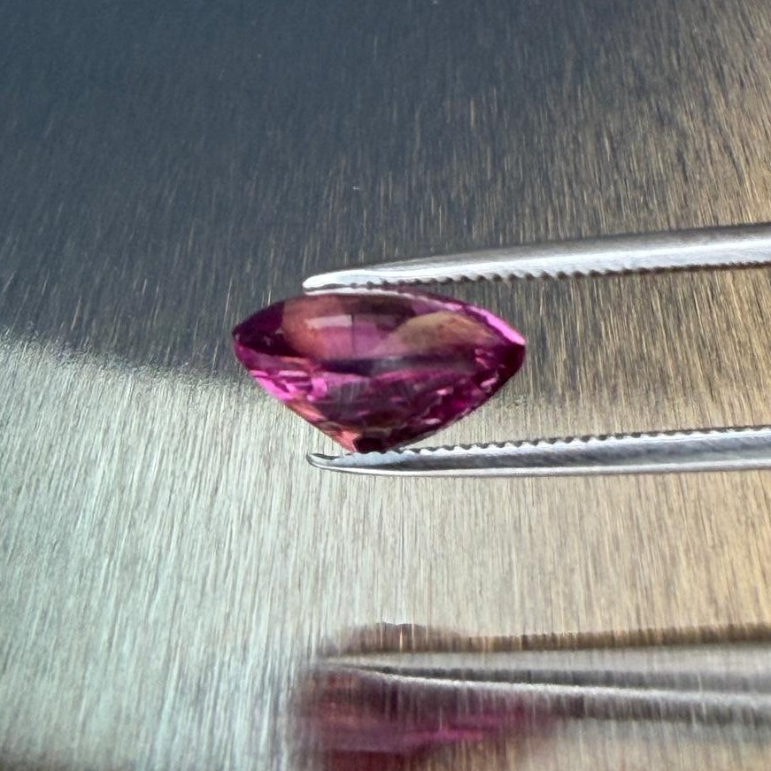 3.19 ct raspberry rhodolite garnet in a pear-shaped buff-top mixed cut, side profile, Otzera OTZ-2026-01649