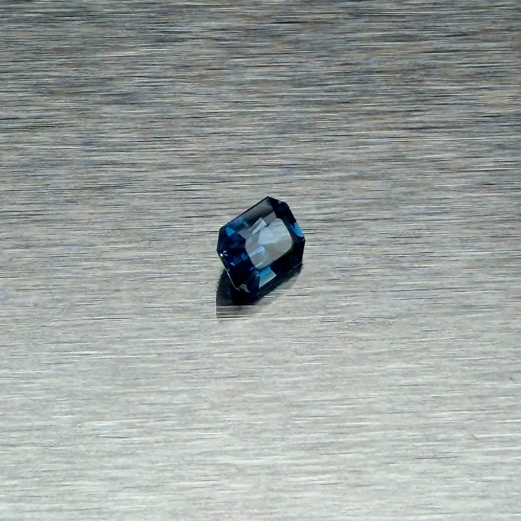 1.00 ct blue sapphire, emerald cut, angled view showing blue flashes, Otzera OTZ-2026-01660