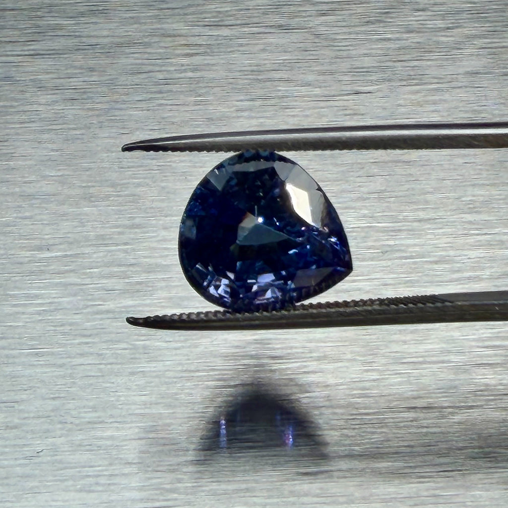 6.75 ct natural tanzanite held in tweezers, face-up pear-cut view, Otzera OTZ-2026-01661