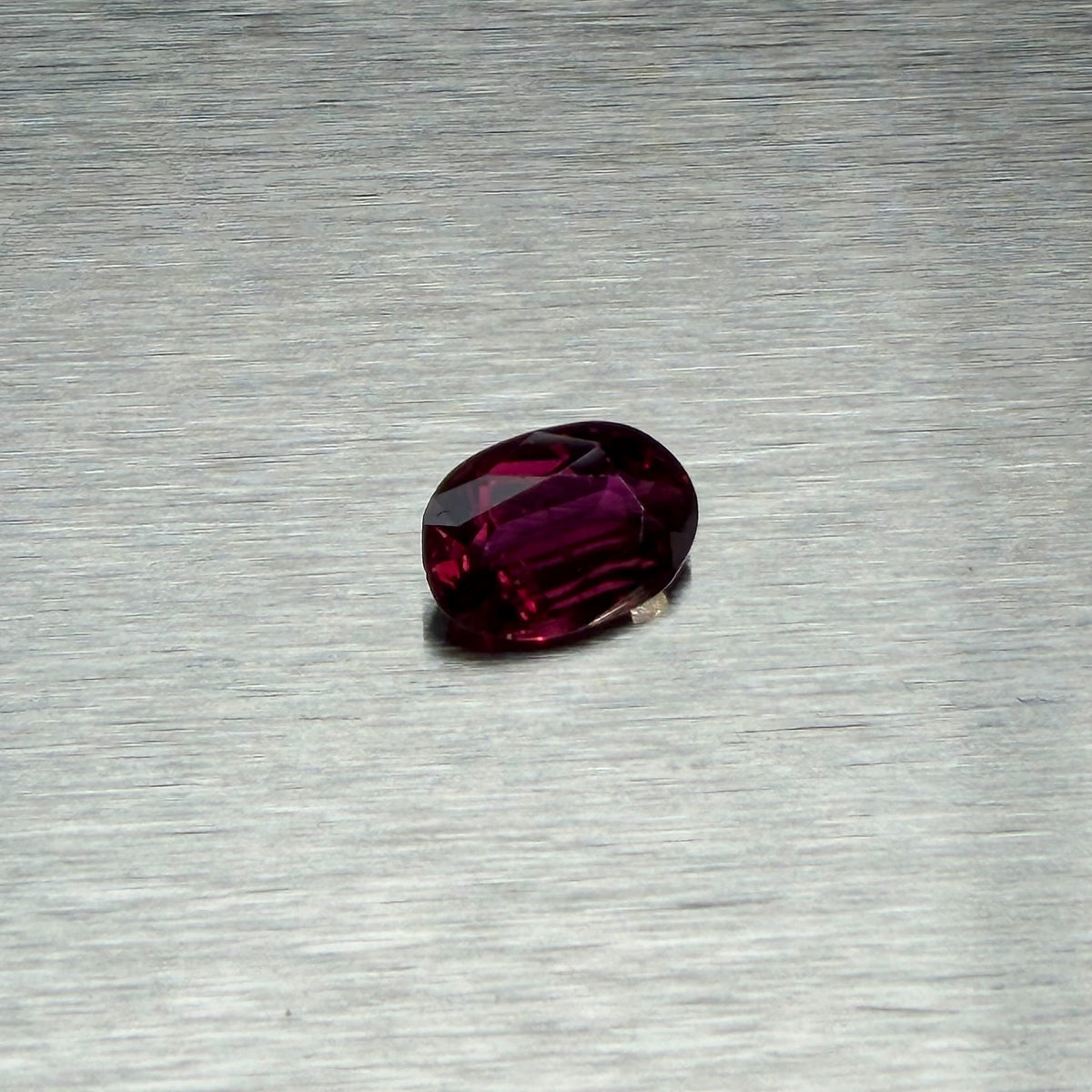 1.82 ct natural ruby, oval mixed cut, angled face-up view showing purplish-red color, Otzera OTZ-2026-01662