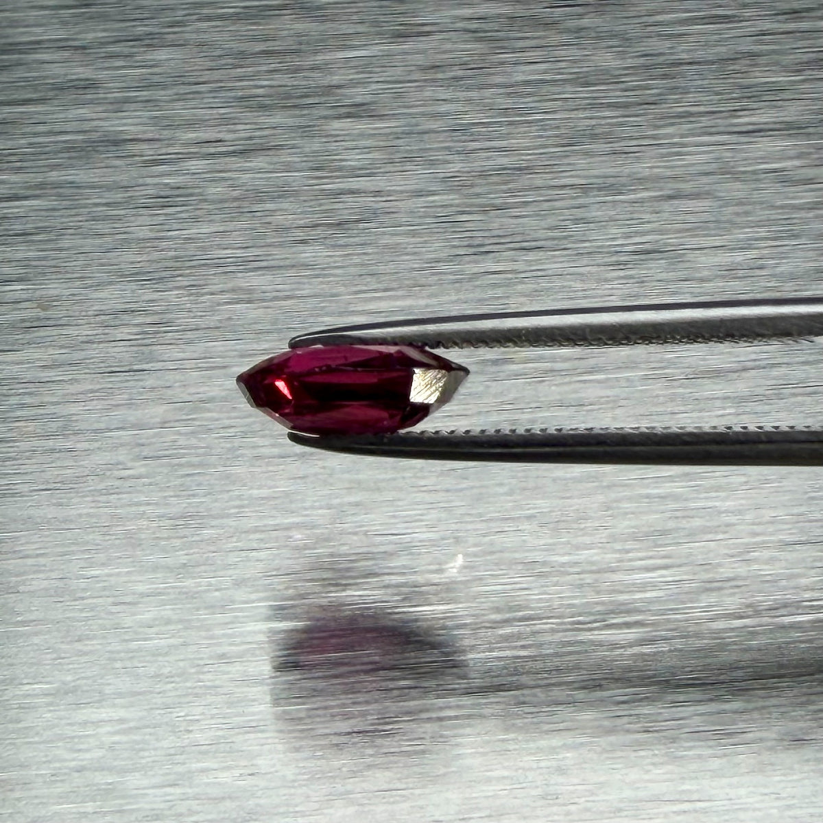1.82 ct natural ruby held in tweezers, side profile showing cut depth, Otzera OTZ-2026-01662