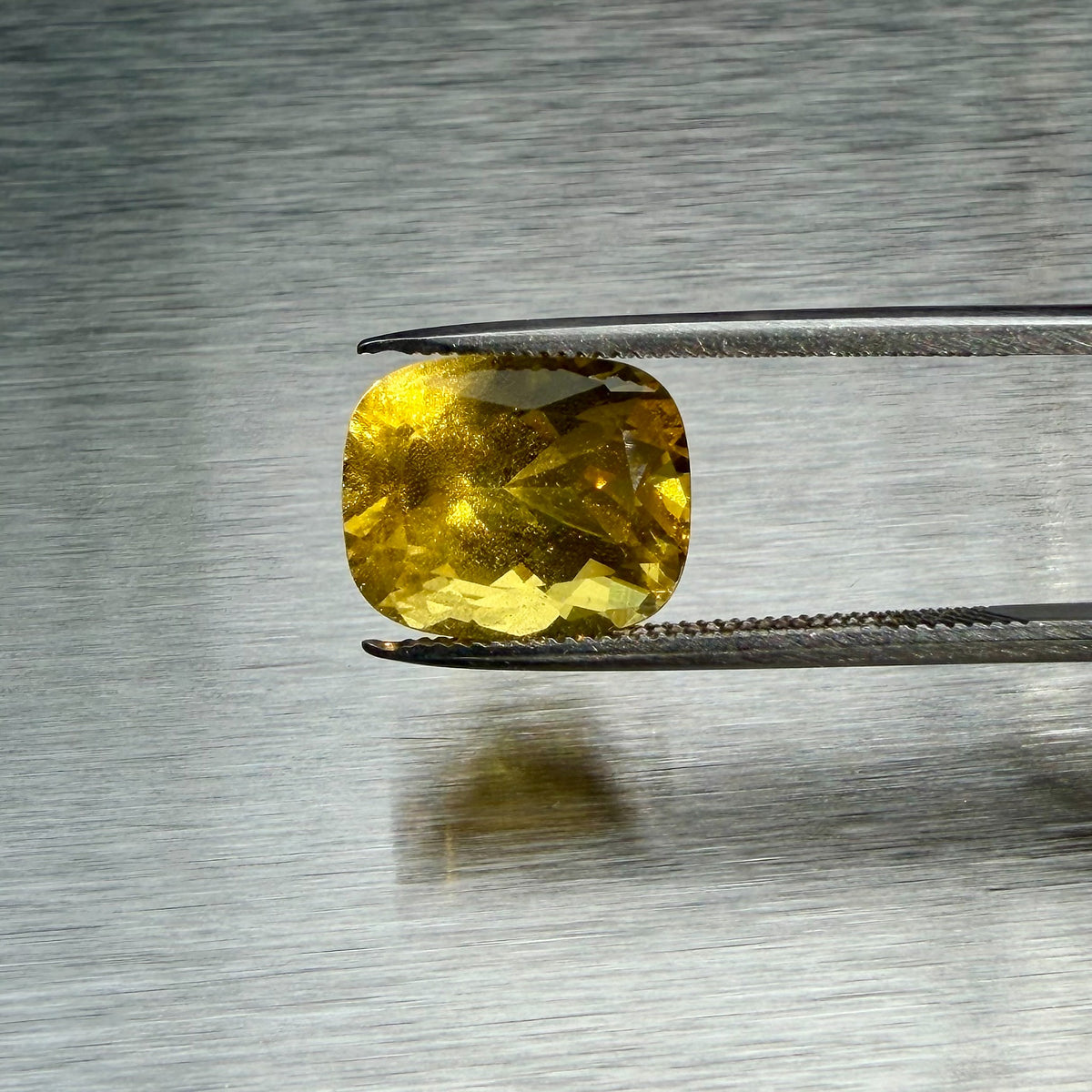 3.85 ct natural golden beryl held in tweezers, face-up cushion view, Otzera OTZ-2026-01663