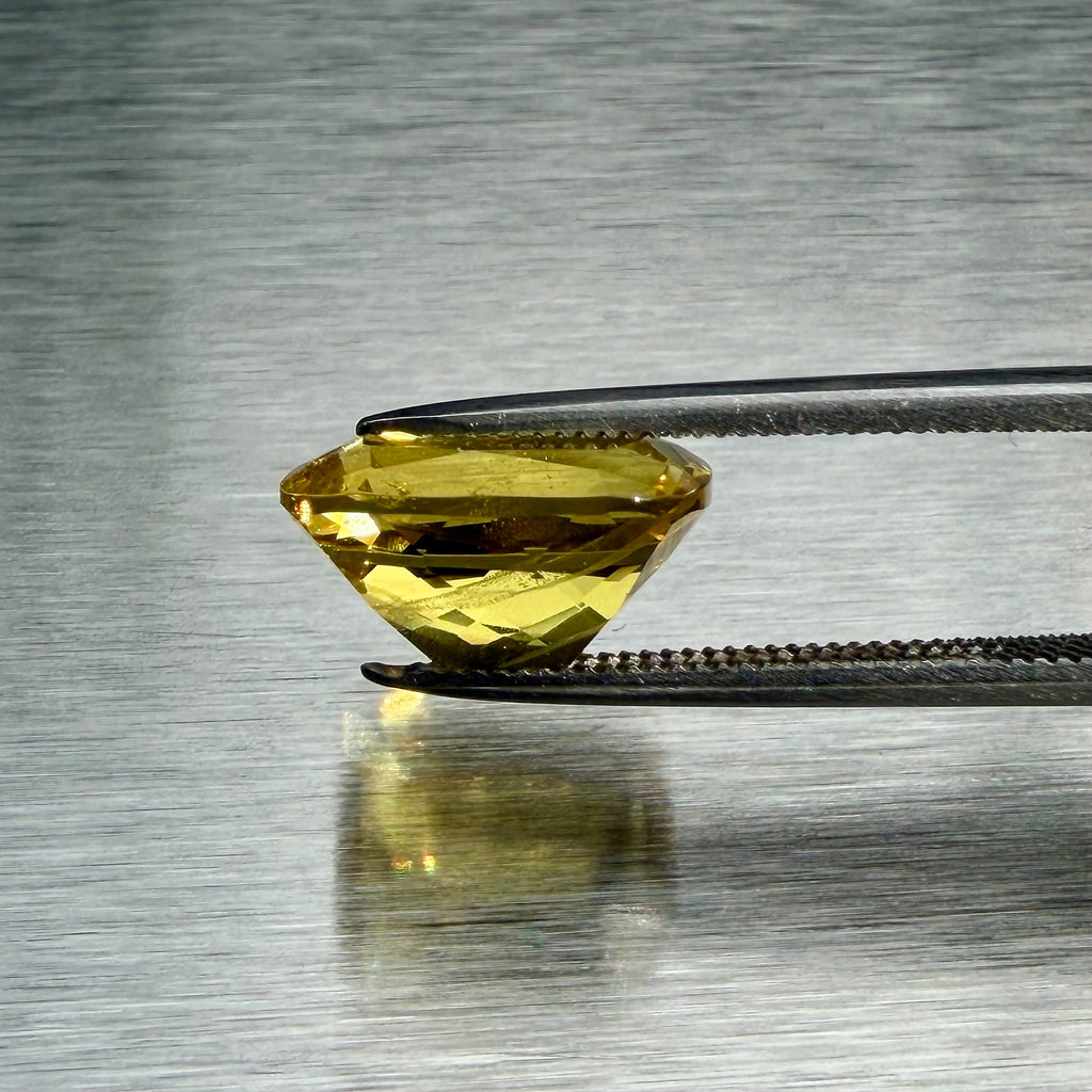 3.85 ct golden beryl heliodor held in tweezers, side profile showing cut depth, Otzera OTZ-2026-01663