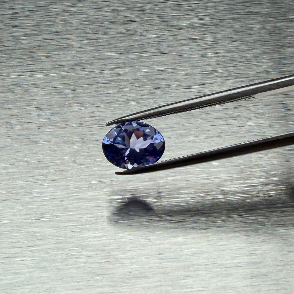 1.44 ct natural tanzanite held in tweezers, face-up oval view, Otzera OTZ-2026-01664