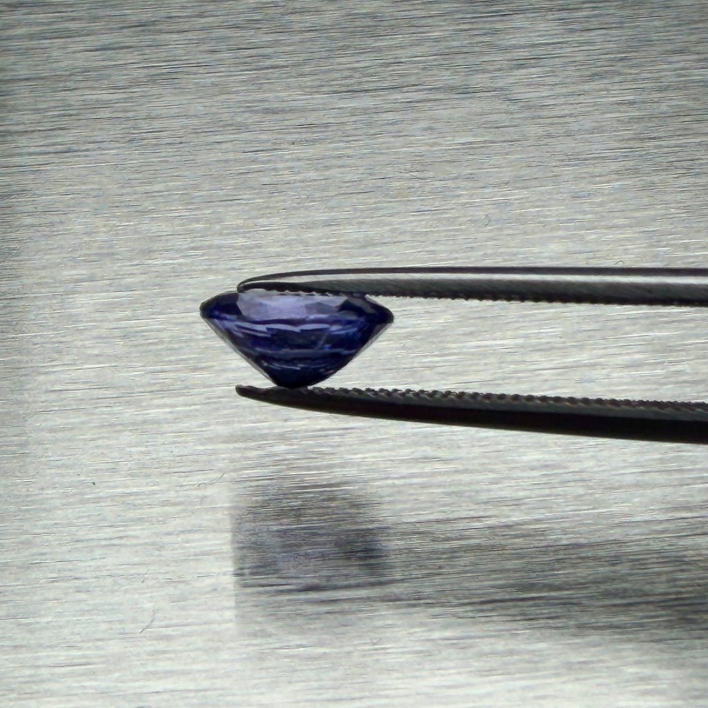 1.44 ct Tanzanian tanzanite held in tweezers, side profile showing cut depth, Otzera OTZ-2026-01664