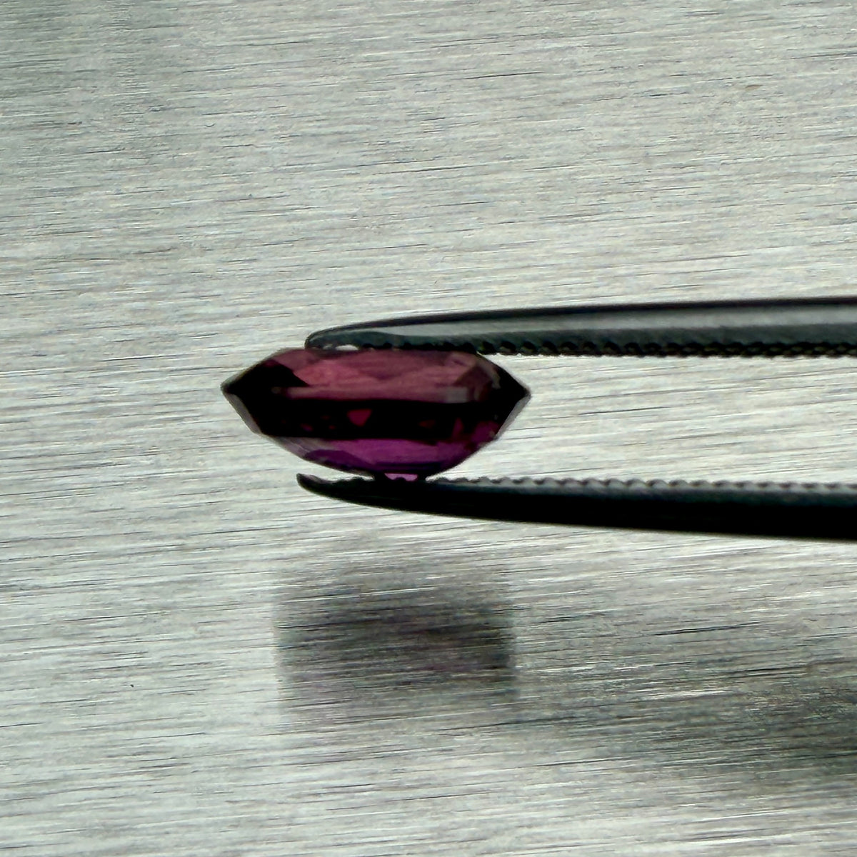 1.66 ct natural ruby held in tweezers, side profile showing cut depth, Otzera OTZ-2026-01665