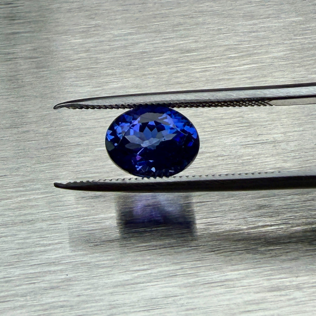 2.08 ct natural tanzanite held in tweezers, face-up oval view, Otzera OTZ-2026-01666