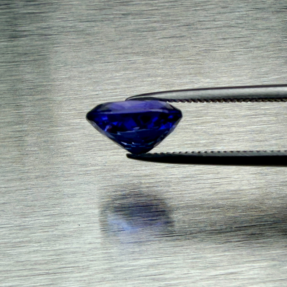 2.08 ct Tanzanian tanzanite held in tweezers, side profile showing cut depth, Otzera OTZ-2026-01666