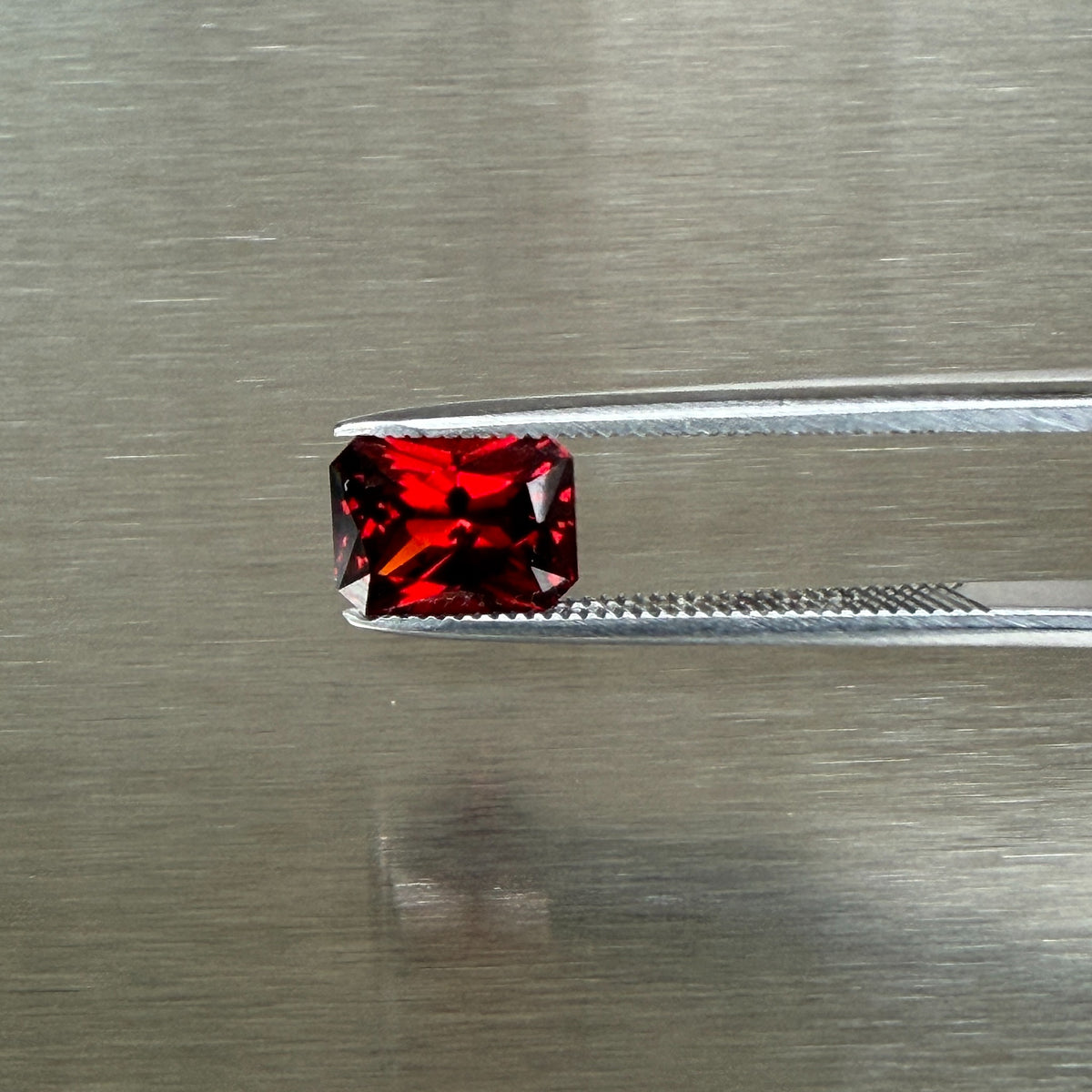 2.18 ct Nigerian spessartite garnet held in tweezers, face-up radiant view, Otzera OTZ-2026-01668