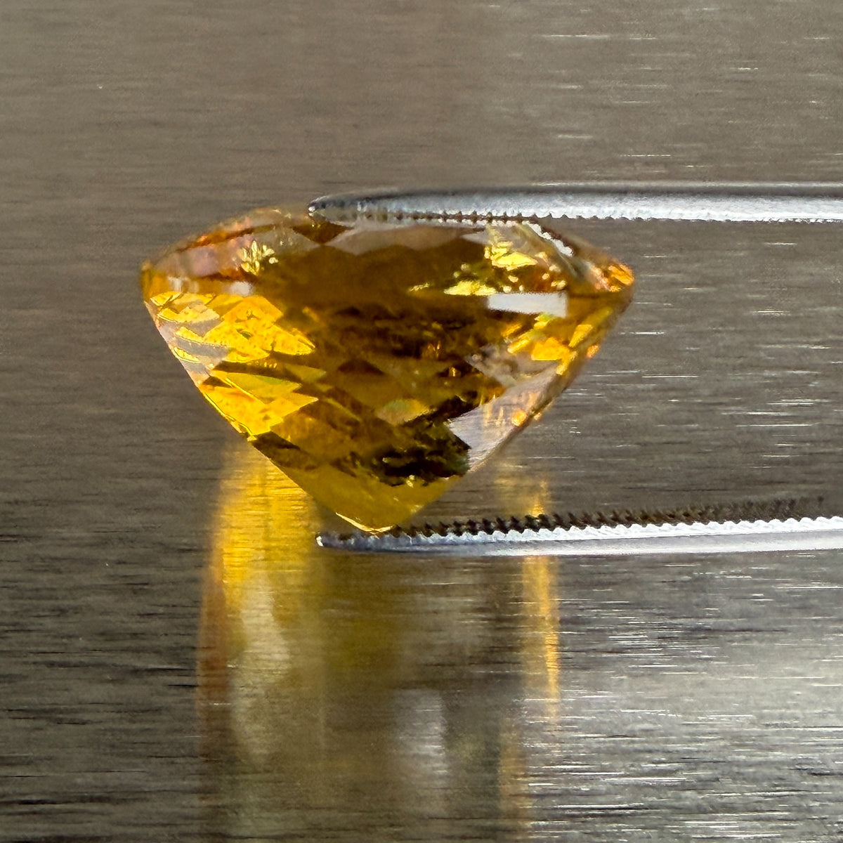 23.93 ct golden beryl heliodor held in tweezers, side profile showing precision cut, Otzera OTZ-2026-01670
