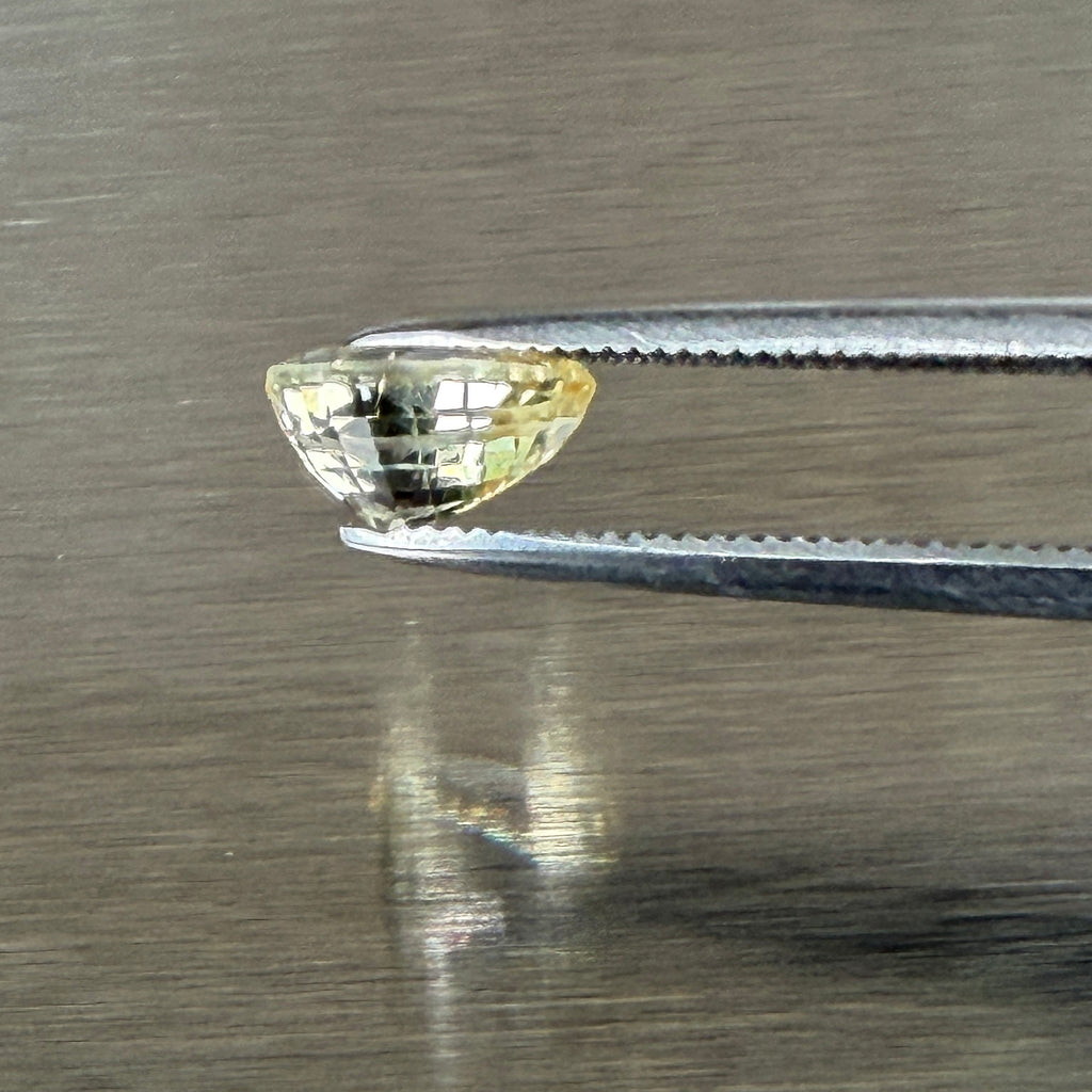 1.24 ct unheated yellow sapphire held in tweezers, side profile showing cut depth, Otzera OTZ-2026-01671
