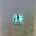 1.71 ct GIA-certified Paraiba-type tourmaline, face-up oval view showing vivid green-blue color.