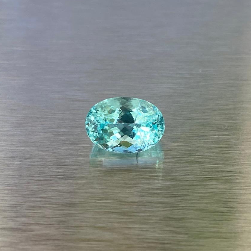 1.71 ct GIA-certified Paraiba-type tourmaline, face-up oval view showing vivid green-blue color.