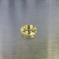 3.83 ct natural yellow chrysoberyl, face-up oval view on a brushed silver background.