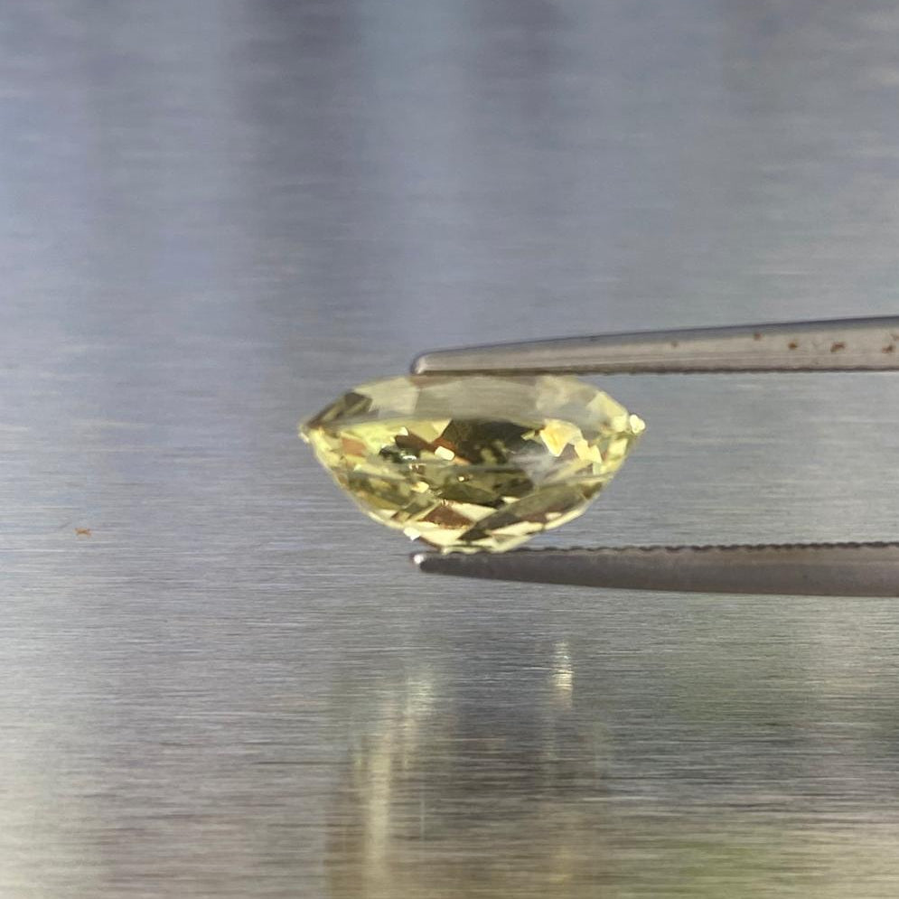 3.83 ct natural yellow chrysoberyl held in tweezers, side profile showing its deep antique cut.